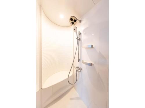 um chuveiro numa casa de banho branca com um espelho em Terrace Toyohira / Vacation STAY 81233 em Sapporo