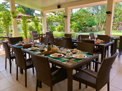 een restaurant met tafels en stoelen met eten erop bij Strutz Art Garden Resort in Bangued