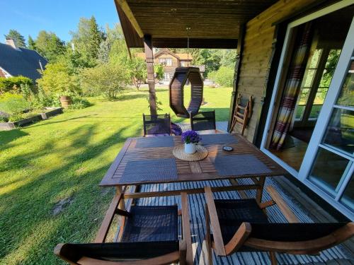 einen Holztisch und Stühle auf einer Veranda in der Unterkunft Norwegian saunahouse in Haapse