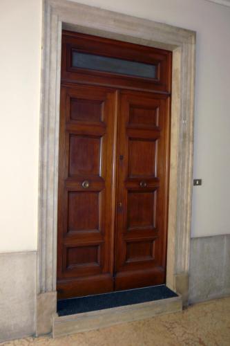 a wooden door in the corner of a building at San Nicolò 3 in Verona