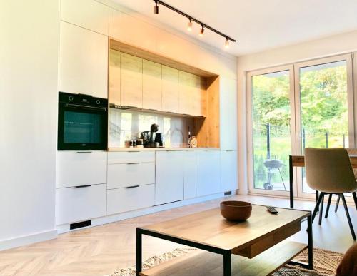 a kitchen with white cabinets and a table at APARTAMENT NA WZGÓRZU in Lidzbark Warmiński