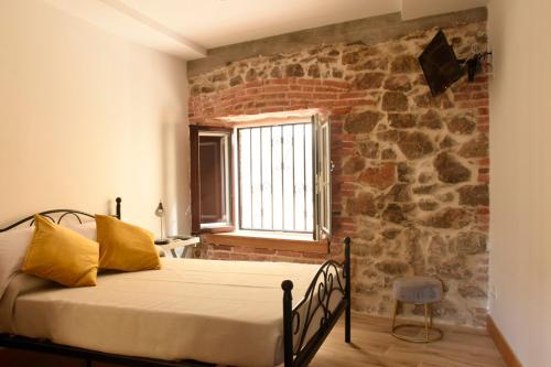 a bed in a room with a brick wall at Apartamentos Tierra y Arte in Santoña