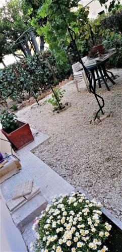 a picnic table and bench in a garden with flowers at Il Giardino di Maura - Aemme2 in Recanati