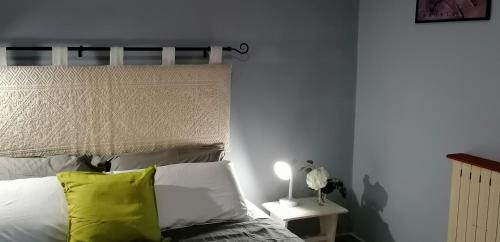 a bedroom with a bed with a yellow pillow at Il Giardino di Maura - Aemme2 in Recanati