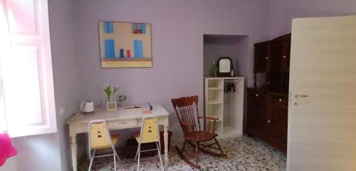 eine Küche mit einem Schreibtisch, 2 Stühlen und einem Kühlschrank in der Unterkunft Il Giardino di Maura - Aemme2 in Recanati