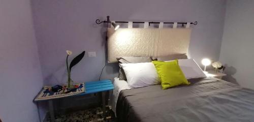 a bedroom with a bed with a yellow pillow at Il Giardino di Maura - Aemme2 in Recanati