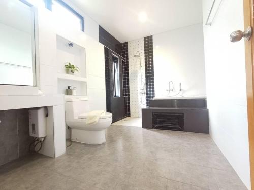 a white bathroom with a toilet and a sink at Richly pool villa@Phitsanulok in Ban Ko