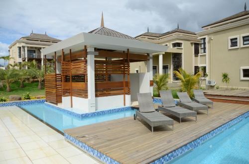 a villa with a pool and a gazebo at Villasun Luxury Apartments & Villas in Flic-en-Flac