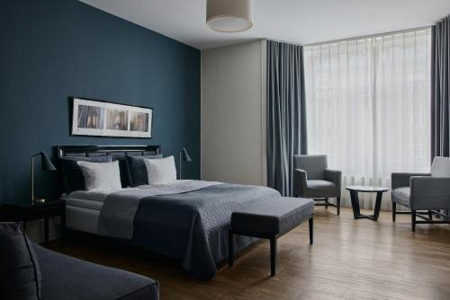 a bedroom with a bed and two chairs and a window at Avenue Hotel Copenhagen by Brøchner Hotels in Copenhagen