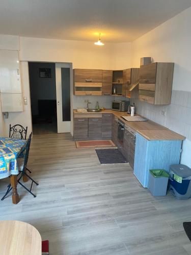 eine Küche mit Holzschränken und einem Tisch darin in der Unterkunft Ruhiges ein Zimmer Wohnung in Idar-Oberstein