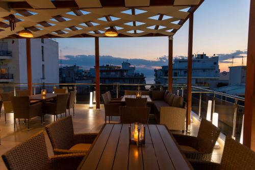 un restaurante con mesas y sillas en un balcón en AGORA luxury BOUTIQUE HOTEL en Loutraki