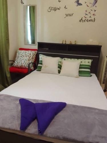 Cainta的住宿－Budget Friendly Staycation in Valley Golf，一间卧室配有一张大床,上面有紫色的领带