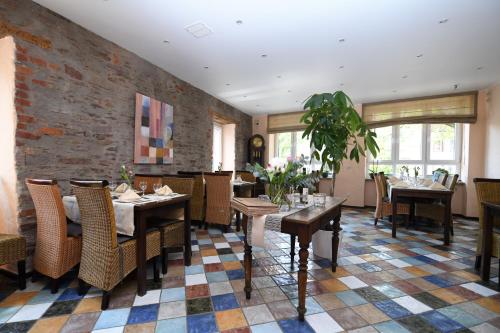 a restaurant with tables and chairs and a brick wall at Hotel Casa Verde in Trier