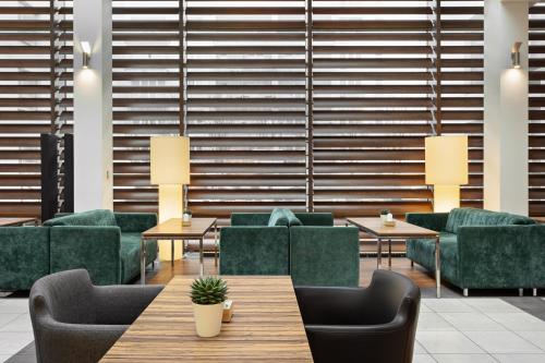 a waiting room with green chairs and tables at Hotel Moderno Poznań in Poznań