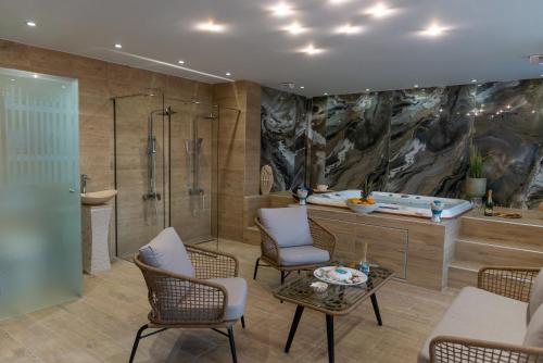 y baño con bañera, mesa y sillas. en AGORA luxury BOUTIQUE HOTEL, en Loutraki