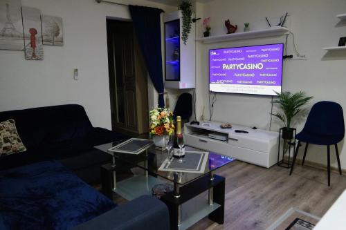 een woonkamer met een bank en een projectiescherm bij Apartament in the City Center in Rokiškis