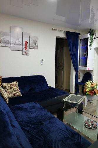 a living room with a blue couch and a glass table at Apartament in the City Center-Old Town in Rokiškis