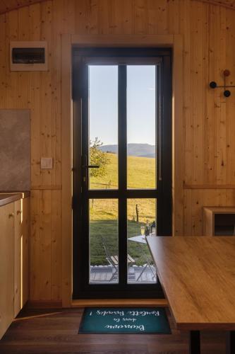 a window in a kitchen with a view of a field at Roulotte Paradis: insolite, SPA privatif, piscine in Chilly