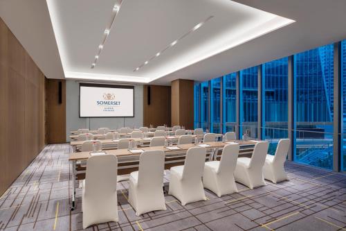 a conference room with a long table and white chairs at Somerset Gaoxin Chengdu in Chengdu