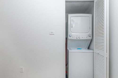 a bathroom with a washer and dryer in a closet at Modern one bed at Beach Walk Miami 15th in Hollywood