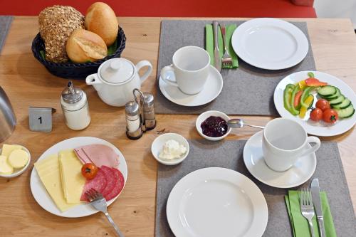 a table with plates and cups and food on it at Bethel Hotel zum Weinberg in Bad Neuenahr-Ahrweiler