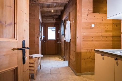 a kitchen with wooden walls and a hallway with a door at Vital Chalet Edelweiss in Schröcken