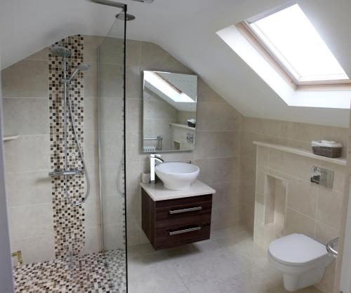 a bathroom with a shower and a toilet and a sink at Lismore House in Newry