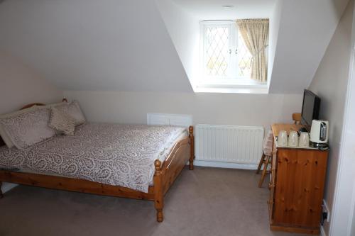 - une chambre avec un lit, une télévision et une fenêtre dans l'établissement Lismore House, à Newry