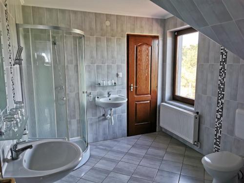a bathroom with a sink and a shower and a toilet at Merlot Borhotel és Látványpince in Edelény