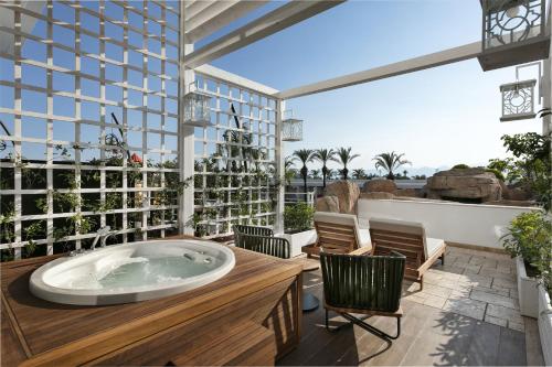 a jacuzzi tub on the patio of a resort at Titanic Deluxe Lara in Lara