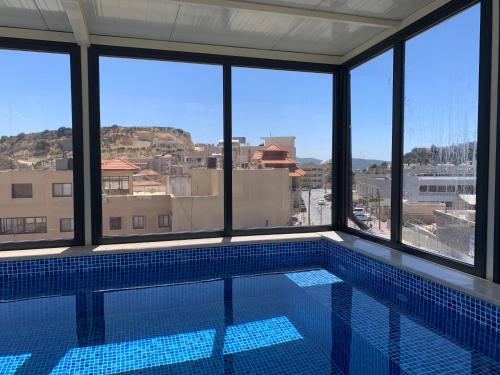 a swimming pool with a view of a building at Uyut apartments in Majdal Shams
