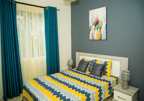 a bedroom with a bed with a yellow and blue at New Luxury 2 Bedroom Apartment with Pool - close to Flic-en-Flac Beach in Flic-en-Flac