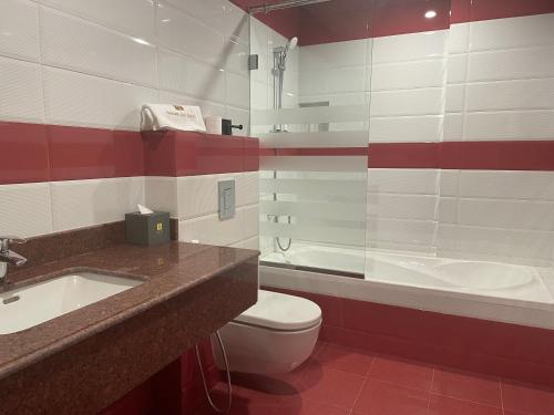 a bathroom with a sink and a toilet and a tub at Season Inn Hotel_Al Hail in Seeb