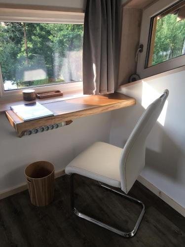 a white chair sitting in front of a window at Oak apartment in Březnice