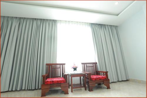 two chairs and a table in front of a large window at Tan Truong Son Hotel in Dong Hoi