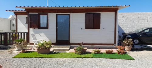 a small house with potted plants in front of it at CasaMya in SantʼAntìoco
