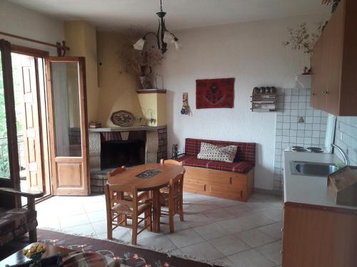 eine Küche und ein Wohnzimmer mit einem Tisch und einem Sofa in der Unterkunft Traditional house in Kalívia