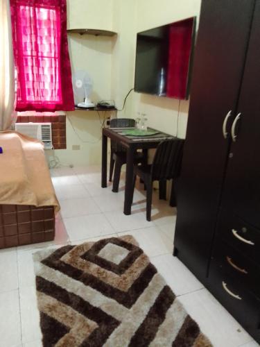 sala de estar con mesa y TV en Affordable Staycation along Ortigas Extension, en Cainta
