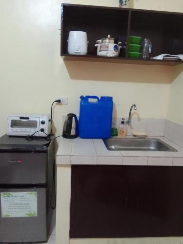 encimera de cocina con fregadero y microondas en Affordable Staycation along Ortigas Extension, en Cainta