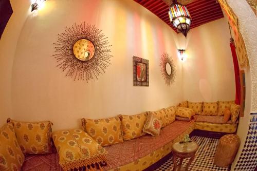 a living room with a long couch in a room at Riad Dar Kassim in Fès