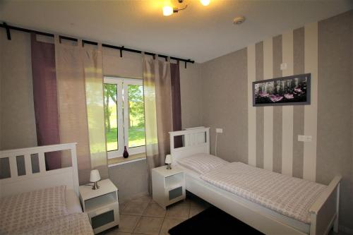 a bedroom with two beds and a window at Ferienwohnung Birkenhof in Volkesfeld