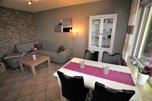 sala de estar con mesa y sofá en Ferienwohnung Birkenhof, en Volkesfeld