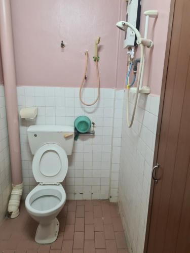 a bathroom with a toilet and two showers at East Coast Hotel in Kuantan
