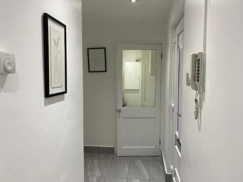 a hallway with a white door and a mirror at Luxurious 2-Bed Apartment in Woolwich London in London