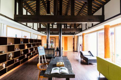 a living room with bookshelves and a table with books at Slow Living Villa in Ninglang