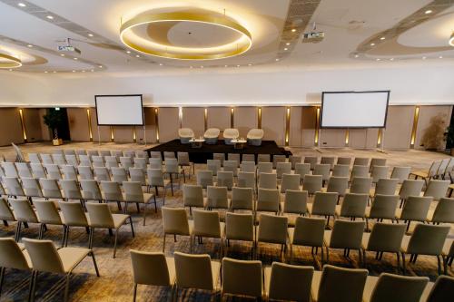 a conference room with chairs and blank screens at Crowne Plaza Belgrade by IHG in Belgrade
