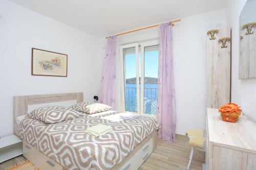 a bedroom with a bed and a large window at Apartments by the sea Rogoznica - 13012 in Rogoznica