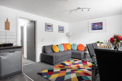salon z szarą kanapą i kolorowymi poduszkami w obiekcie Malone Crescent Apartment - 2BR, 2B in City Centre w mieście Belfast