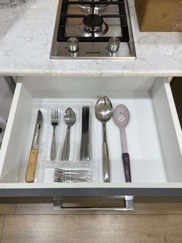 a kitchen sink with silver utensils in it at Kvartira in Quba