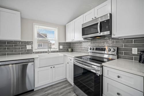 a kitchen with white cabinets and a stove top oven at Beach Getaway Parking 2 blocks to Beach in Brigantine